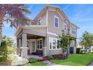 Charming two-story home with a covered front porch and beautifully landscaped yard at 13241 Cormack Ln, Orlando, FL 32827