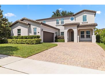 Stunning two-story home boasts a tile roof, brick driveway, manicured landscaping, and an attached two-car garage at 16753 Gullfloss Ter, Winter Garden, FL 34787