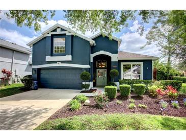 Charming two-story home with a blue exterior, beautiful landscaping, and well-manicured lawn at 1740 Cherry Ridge Dr, Lake Mary, FL 32746