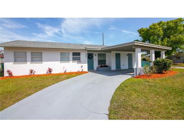 Charming home with a covered entry, long driveway, and nicely landscaped yard with colorful plantings at 1831 Aaron Ave, Orlando, FL 32811