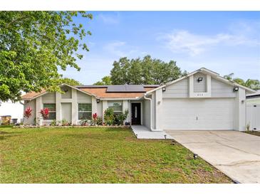 Charming single-story home with well-manicured lawn, flower beds, and a two-car garage at 211 Dalton Dr, Kissimmee, FL 34758