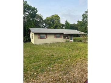 Modest single-story home featuring red trim and a covered front entrance at 2207 Virginia Ave, Eustis, FL 32726