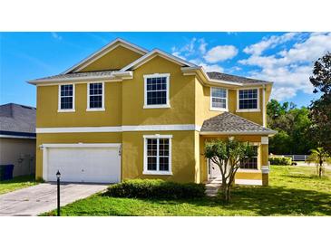 Charming two-story home featuring a well-maintained lawn, bright exterior paint and an attached two car garage at 369 James Cir, Lake Alfred, FL 33850