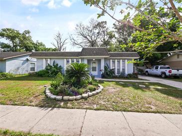 Charming single-story home with well-manicured landscaping and a classic facade with columns at 4025 Luan Dr, Orlando, FL 32808