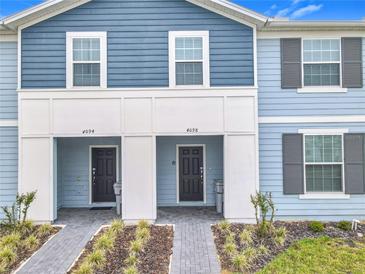 Charming townhome exterior featuring a two-tone facade, well-manicured landscaping, and inviting front entrances at 4098 Lana Ave, Davenport, FL 33897