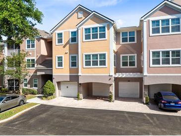 Beautiful three-story townhome featuring an attached two car garage and neutral paint colors at 6685 Queens Borough Ave # 202, Orlando, FL 32835
