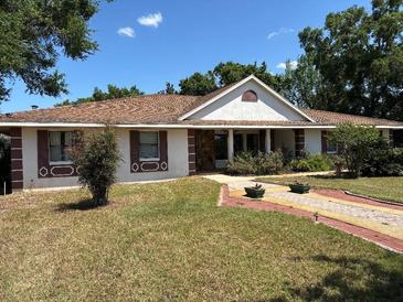 Charming single-story home featuring a well-manicured lawn, brick-lined driveway, and attractive shutters at 9538 Lavill Ct, Windermere, FL 34786