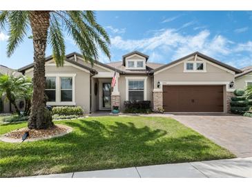 Charming home boasts a lush green lawn, palm tree and manicured landscaping at 5004 Hartwell Ct, St Cloud, FL 34771