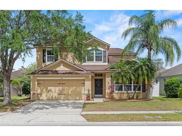 Charming two-story home featuring a well-maintained lawn, mature trees, and an attached two-car garage at 108 Portstewart Dr, Orlando, FL 32828
