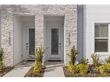 Modern townhome front entrances feature stone accents, contemporary doors, and manicured landscaping at 17407 Hidden Forest Dr, Clermont, FL 34714