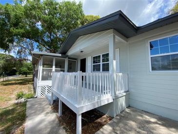 Charming home exterior featuring a screened porch and a front porch with white railing at 545 Brooks Ct, Polk City, FL 33868