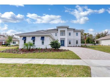 Stunning two-story home featuring a modern facade, meticulously landscaped yard, and a welcoming paver driveway at 10013 Brocksport Cir, Gotha, FL 34734