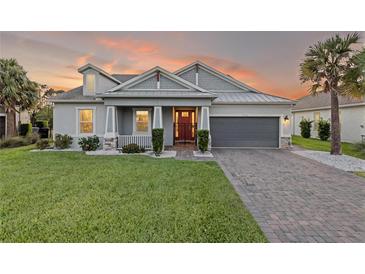 Charming single-story home with well-manicured lawn and a gray two-car garage at 1062 Lakeside Estates Dr, Apopka, FL 32703