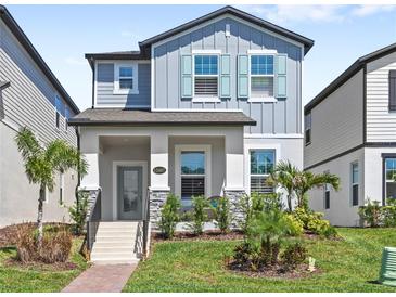 Charming two-story home with gray siding, teal shutters, and beautifully landscaped front yard at 12067 Eastmoor Dr, Winter Garden, FL 34787