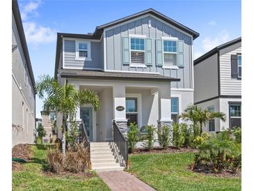 Charming two-story home featuring a well-manicured lawn, a welcoming porch, and a beautifully landscaped front yard at 12067 Eastmoor Dr, Winter Garden, FL 34787