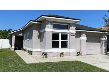 Charming single-story home featuring a neutral stucco finish, white trim, and an attached two-car garage at 13416 Greenpointe Dr, Orlando, FL 32824