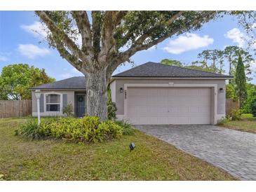 Charming home exterior featuring a 2-car garage, inviting front yard, and mature landscaping with a large shade tree at 14620 Old Forest Ct, Orlando, FL 32826