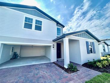 Charming two-story home featuring brick paver driveway, attached two-car garage, and welcoming entrance at 1513 Congaree St # 1513, Davenport, FL 33837