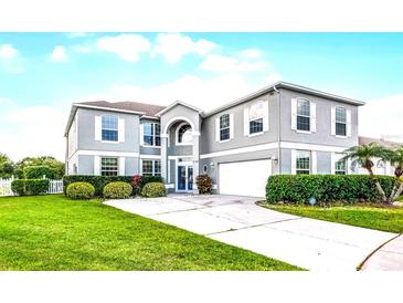 Beautiful two-story home with a well-manicured lawn and driveway leading up to the attached two-car garage at 219 Strathmore Cir, Kissimmee, FL 34744