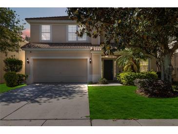 Charming two-story home features a well-maintained lawn and an attached two-car garage at 2509 Archfeld Blvd, Kissimmee, FL 34746