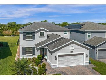 Beautiful two-story home with well-maintained landscaping and a two-car garage on a sunny day at 2613 Camden Park Loop, Davenport, FL 33837