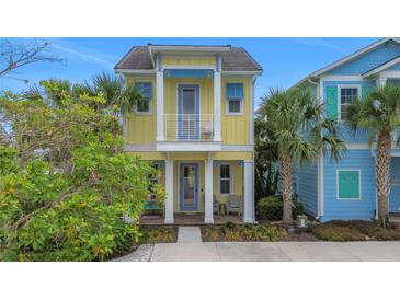 Charming two-story home with a yellow exterior, blue trim, and a small front porch at 3083 Key Lime Loop, Kissimmee, FL 34747