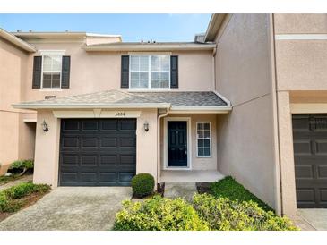 Charming two-story townhome with a one car garage, black shutters, and well-maintained landscaping at 5004 Ashford Falls Ln, Oviedo, FL 32765