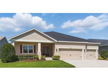 Inviting single-story home showcasing a manicured lawn and a convenient two-car garage at 5829 Valentino Way, Lakeland, FL 33812