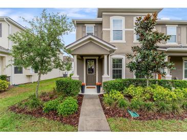 Charming two-story townhome with inviting front entrance and well-manicured landscaping at 9433 Randal Park Blvd, Orlando, FL 32832