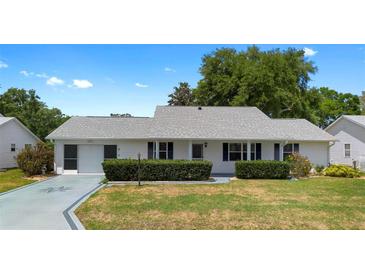 Charming single-story home with well-manicured lawn and established landscaping at 25929 Newcombe Cir, Leesburg, FL 34748