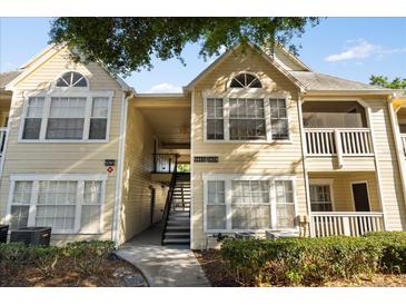 Charming yellow two-story condo building with well-maintained landscaping and inviting entryway at 1063 S Hiawassee Rd # 1615, Orlando, FL 32835