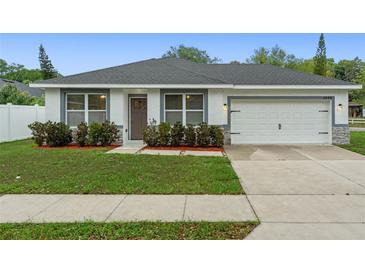 Charming single-story home with a well-maintained lawn, landscaping, and a two-car garage at 1440 Lake Shore Dr, Casselberry, FL 32707