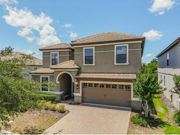 Charming two-story home featuring a tile roof, two-car garage, and landscaped front yard, perfect for families at 1491 Rolling Fairway Dr, Davenport, FL 33896