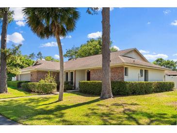 Charming single-story home with brick accents, a well-manicured lawn and mature trees adding to its curb appeal at 400 Woodview Dr, Longwood, FL 32779