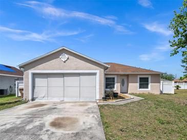 Charming single-story home with a large two car garage, and a well-maintained front yard at 62 York Ct, Kissimmee, FL 34758