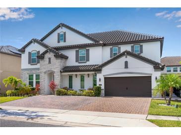 Beautiful two-story home featuring a brick driveway and stone accents, along with a two car garage at 8109 Ludington Cir, Orlando, FL 32836