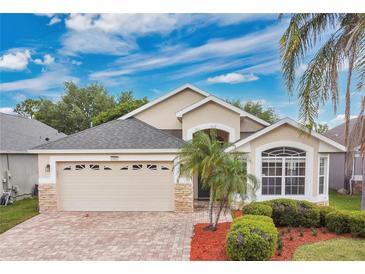 Charming single-story home with a two car garage, manicured landscaping, and brick paved driveway at 10621 Golden Cypress Ct, Orlando, FL 32836