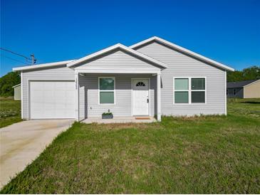 Charming single-story home featuring a well-manicured lawn, attached garage, and a classic white front door at 12388 Se 106Th Ave, Belleview, FL 34420