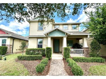 Charming two-story home featuring a covered porch, lush landscaping, and a welcoming entrance at 15157 Pigeon Plum Ln, Winter Garden, FL 34787
