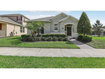 Charming single-story home featuring a beautifully landscaped front yard with manicured bushes and a paver walkway at 16892 Hypatia Aly, Winter Garden, FL 34787