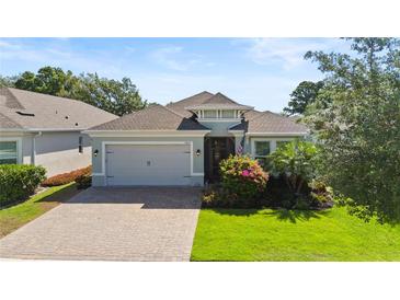 Charming single-story home featuring a well-maintained lawn and a two-car garage with paver driveway at 1925 Estuary Ln, Kissimmee, FL 34747
