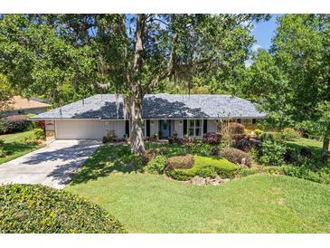 Charming single-story home showcasing lush landscaping and mature trees, offering serene curb appeal and a welcoming atmosphere at 210 Lonesome Pine Dr, Longwood, FL 32779