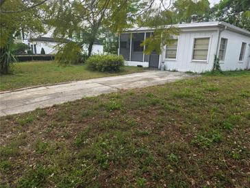 A single-story home with a front yard and a concrete driveway leading up to the screened-in porch at 2507 Lafayette Ave, Winter Park, FL 32789