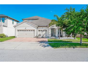 Charming single-Gathering home with a well-manicured lawn and a three-car garage on a sunny day at 3041 Cardillino Way, Kissimmee, FL 34741