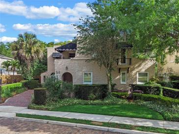 Stunning two-story home with lush landscaping, brick driveway, and charming architectural details at 511 Woodlawn Blvd, Orlando, FL 32801