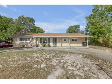 Charming single-story home with a covered parking area and well-maintained front lawn at 825 Second St, Orange City, FL 32763