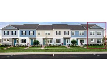 A modern townhome showcasing light-colored siding, black shutters, and professional landscaping at 1484 Silver Lining Way, Apopka, FL 32703