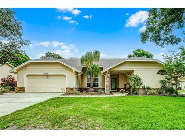 Charming single-story home featuring manicured lawn, two-car garage, and beautiful landscaping at 10119 Bayard Ct, Orlando, FL 32836