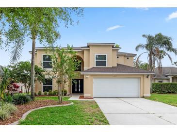 Charming two-story home with a well-manicured lawn and attached two car garage at 1018 Oceanbreeze Ct, Orlando, FL 32828