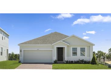 Charming single-story home with a two-car garage, well-manicured lawn, and inviting entryway at 1026 Vineyard Ridge Rd, Minneola, FL 34715